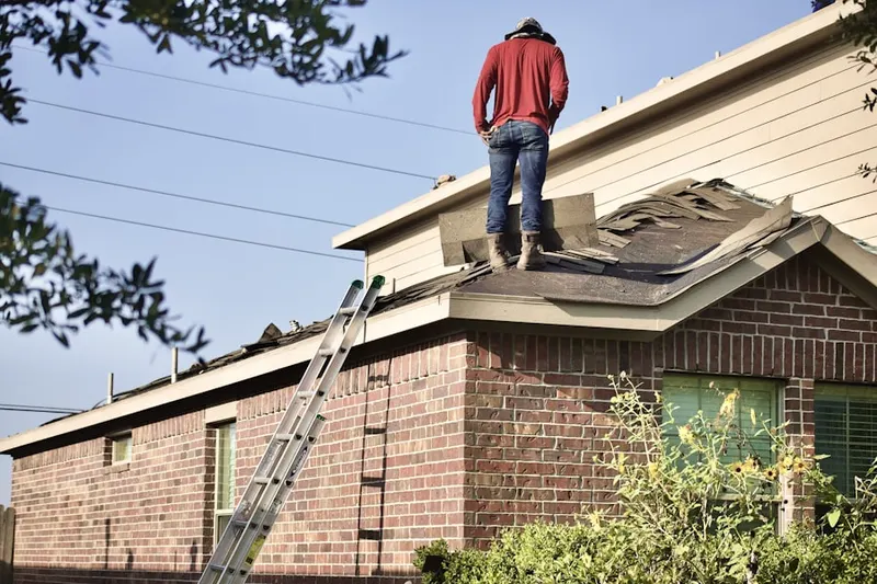 Professional roofer working on a residential roof in The Heritage